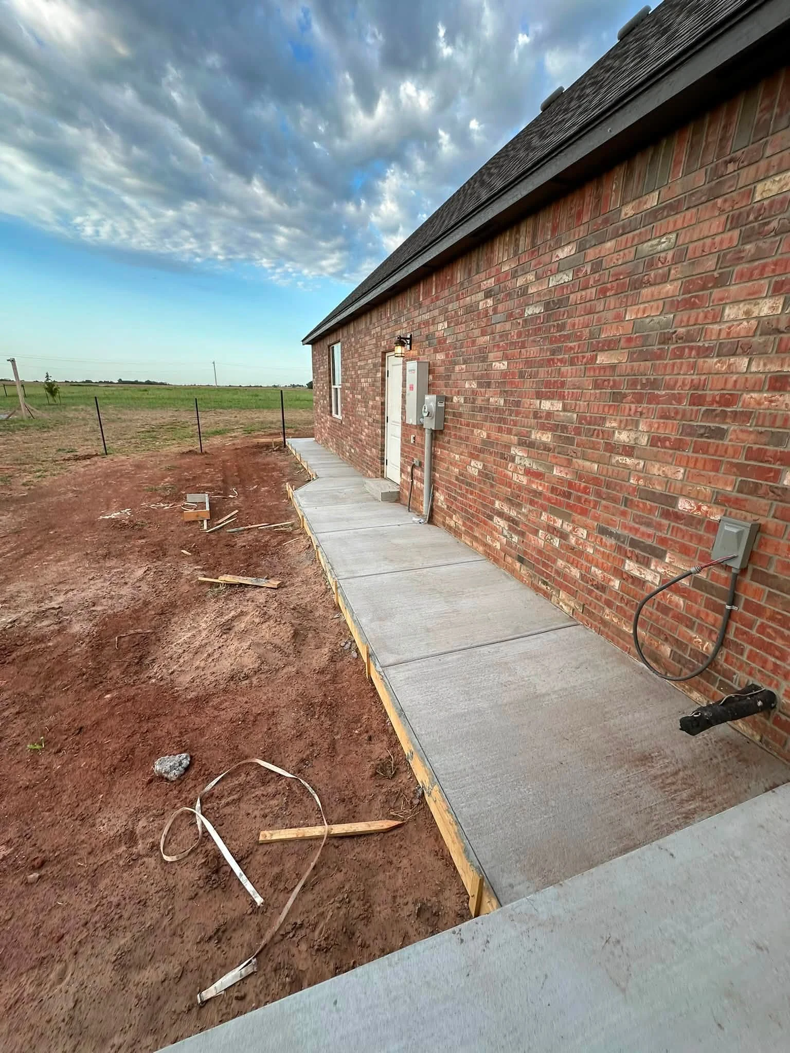 EMS concrete sidewalk along a brick home